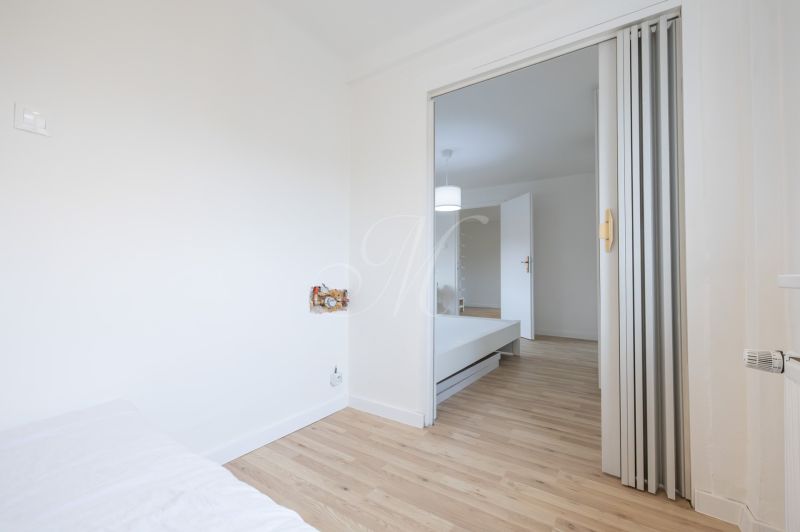 Interior of a 2-room apartment with a wooden decor floor and sliding doors.