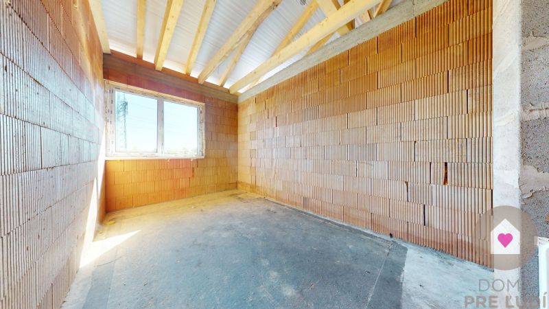 An unfinished room in a house under construction with a large window.