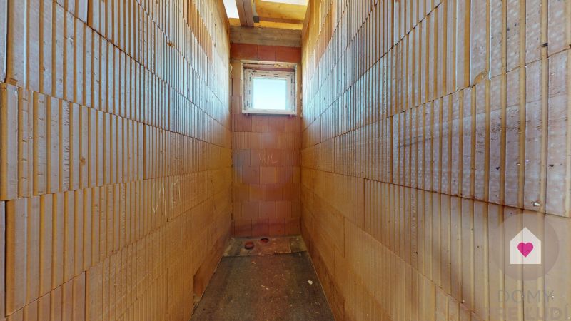 A narrow brick room with a small window in a family house.