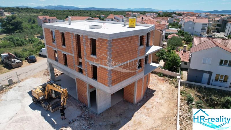 Construction of a recreational apartment in Vodice with brick walls and a view of the surrounding houses.