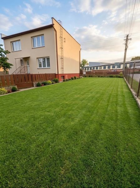 A family house in Záhorská Ves with a manicured lawn and simple fencing.