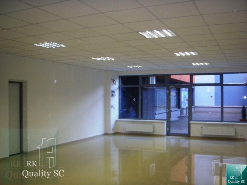 Offices with large windows and light-colored walls, floor with wooden decor.
