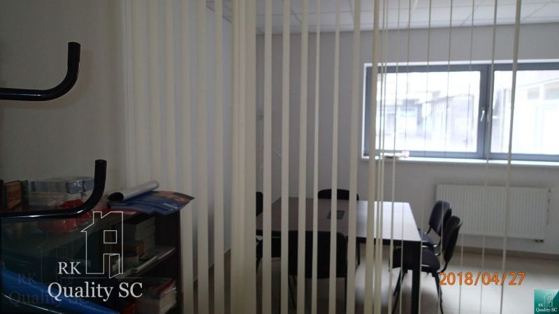 Meeting room with a window and vertical blinds in the office, table and chairs.