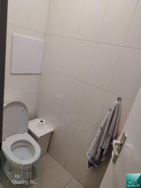 Toilet with wall tiles, toilet, towel, and bin in Offices.