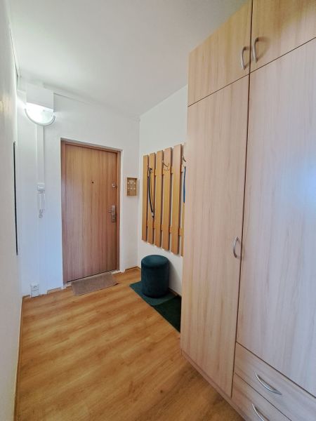 Entrance hallway with wood-patterned flooring, coat hooks, and a wardrobe in a 3-room apartment.