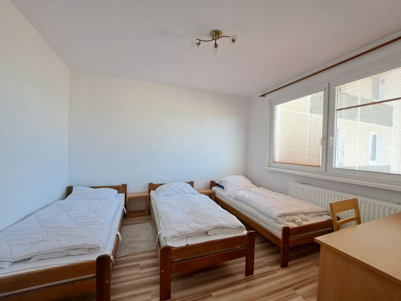 Three single beds, wooden decor, bright room, 3-room apartment.
