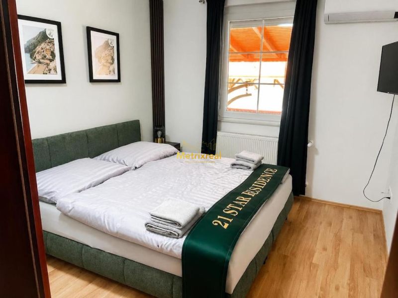 Bedroom with a double bed, wooden decor flooring, wall decorations.