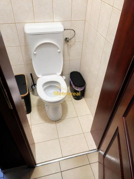 A toilet with a white ceramic bowl and tiles in a family house.