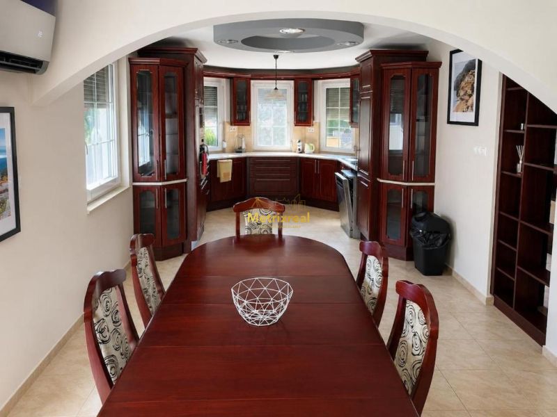 A kitchen in a family house with wooden furniture and a dining table.