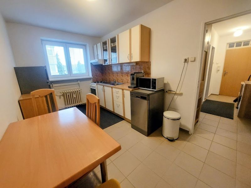 Kitchen in a 2-room apartment with a dining table and appliances.