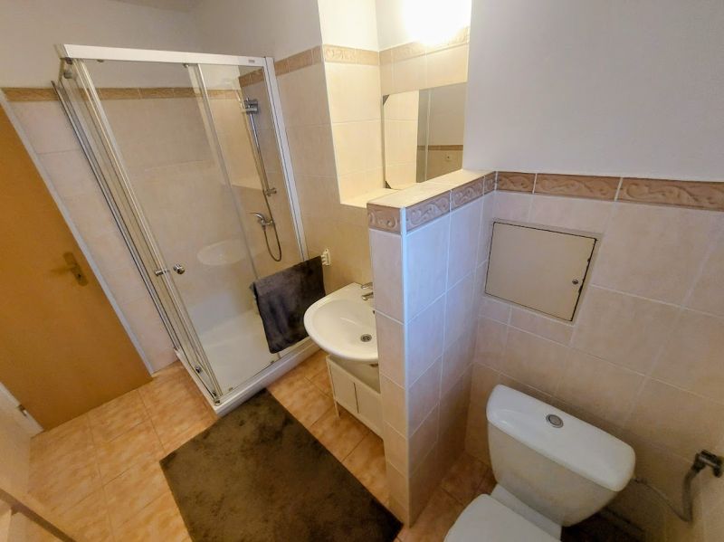 Bathroom with a shower and a sink in a 2-room apartment.