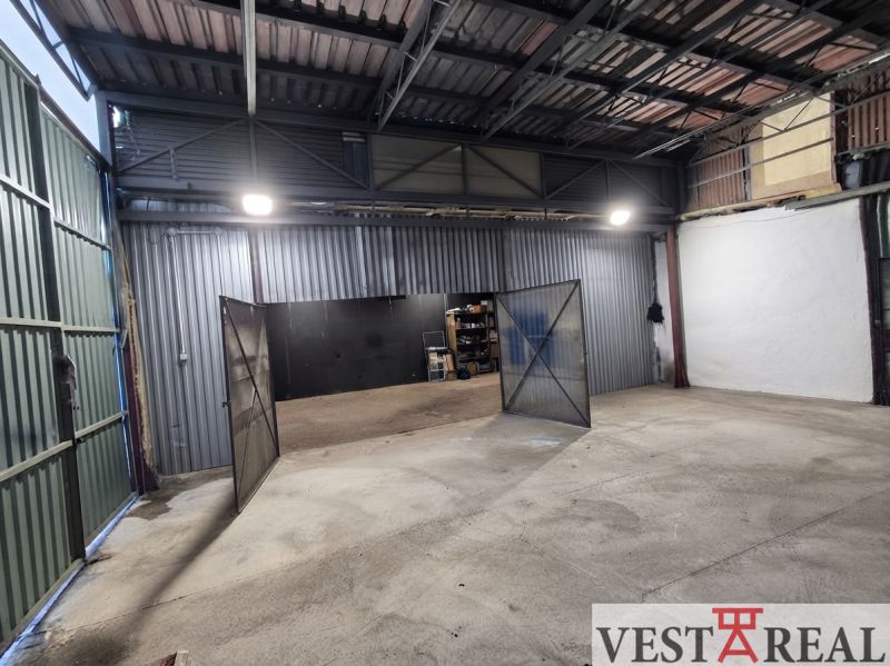 Warehouses and halls with metal doors and high ceilings.