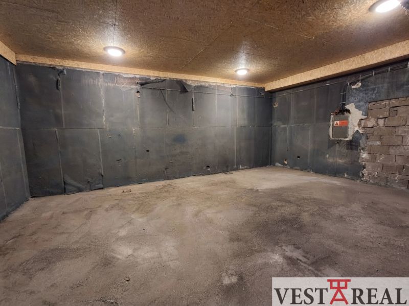 A space with a concrete floor and lighting, ideal for storage purposes.