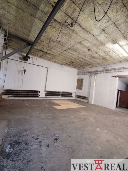 Empty interior in warehouses and halls with concrete floor and pipes on the wall.