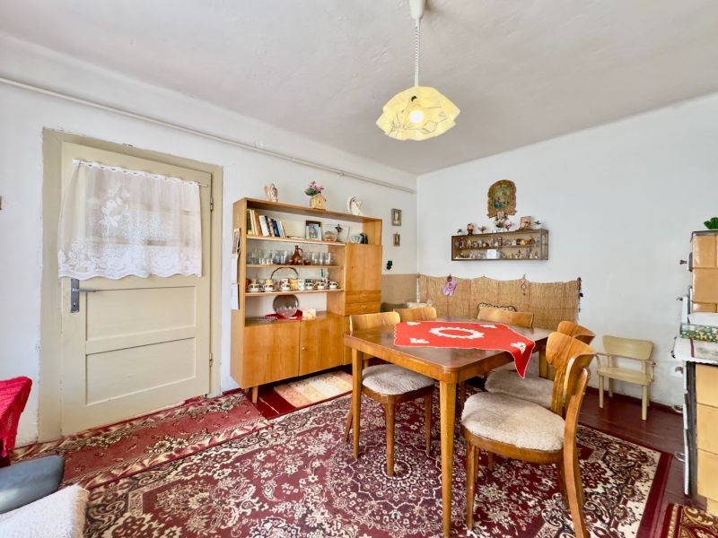 Dining room in a family house with wooden furniture and a red carpet.