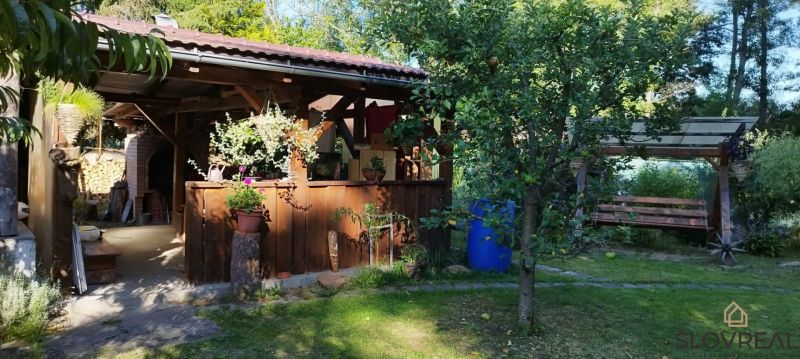 A cottage in Lutila with a wooden terrace, a swinging bench, and surrounding greenery.