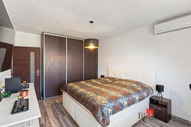 A bathroom in a 2-room apartment with a glass shower enclosure and tiles with a blue pattern.