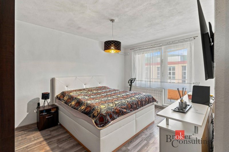 Dining area with a table and chairs in a 2-room apartment with a wooden decor floor.