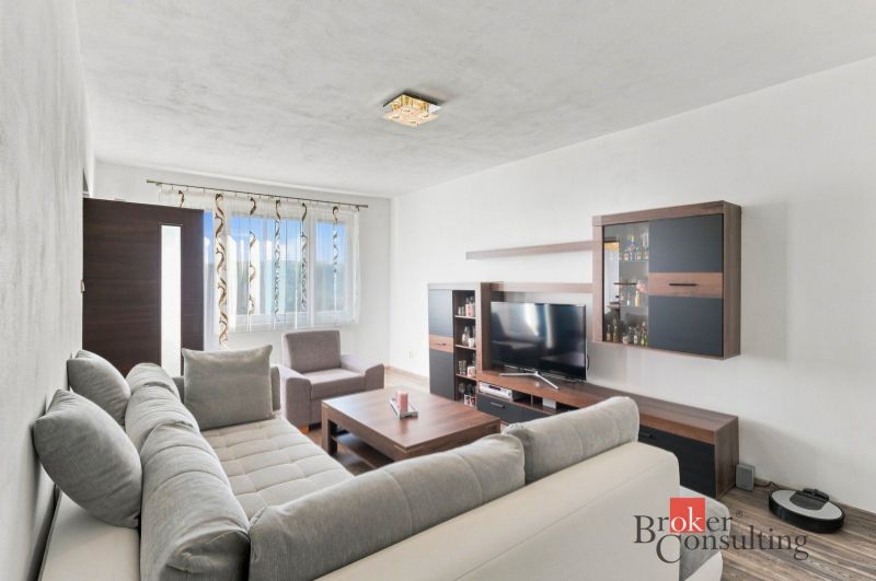 A kitchen in a 2-room apartment with a wooden floor decor and stainless steel appliances.