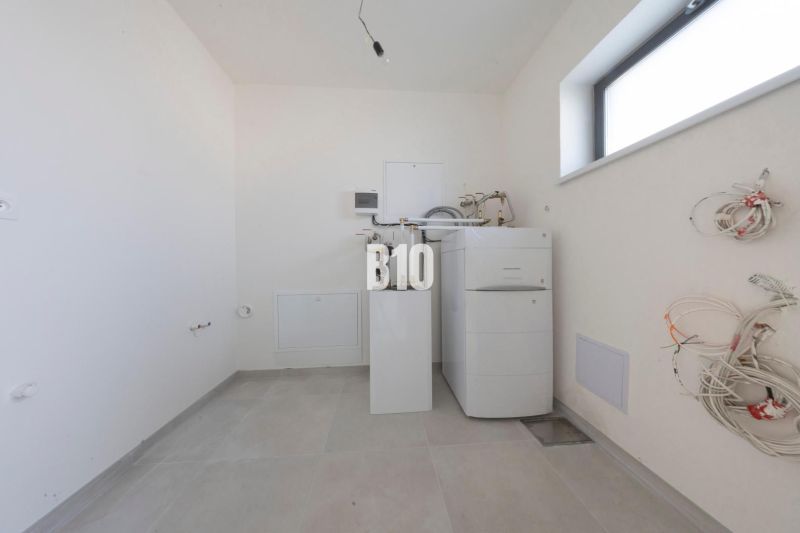 Utility room with a boiler and water connections in a family house.