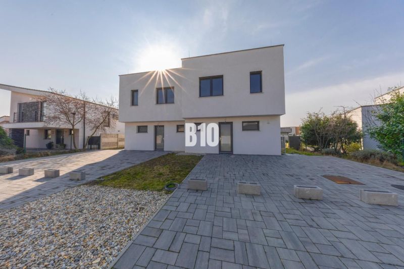 A family house in Senec on a street in Senec with a landscaped yard and paving.