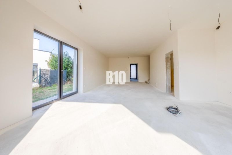 In the family house, there is a bright room with large glazing and access to the garden.