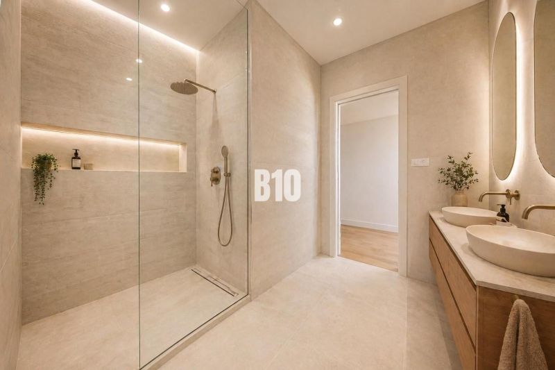 A bathroom in a family house with a sliding shower enclosure, sinks, and a plant.