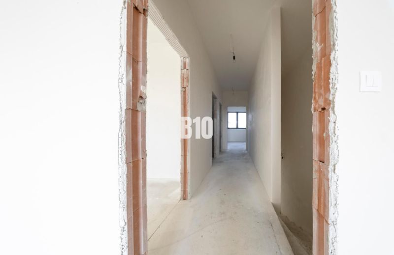 A hallway with white walls and unfinished doors in a family house.
