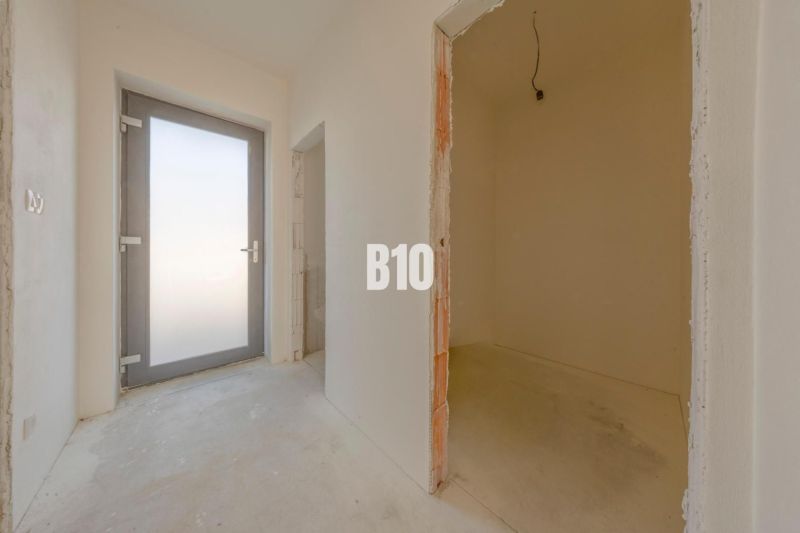 Entrance hall with concrete floor and glass doors in a family house.