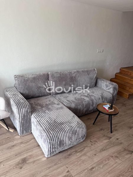 A stylish gray sofa combined with a wooden decor floor in the cottage.