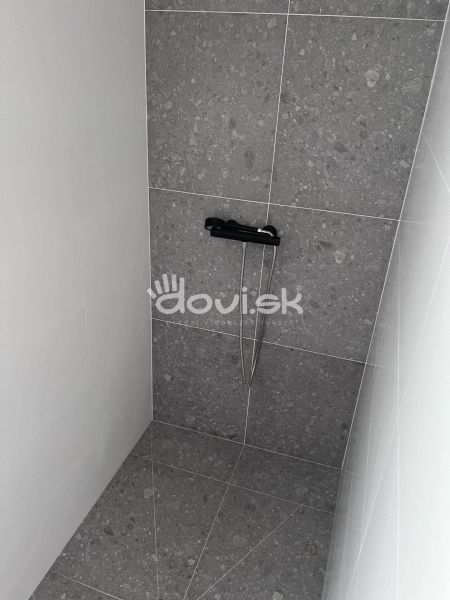 Shower corner with dark tiles in the Cottage.