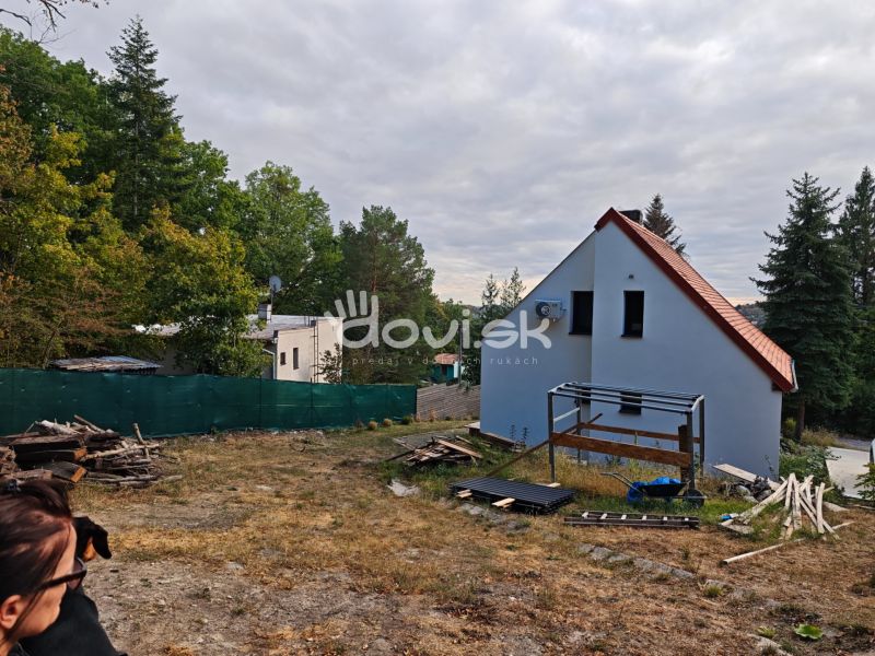 A cottage in Kaluža on Kamenec Street surrounded by green trees and open space.