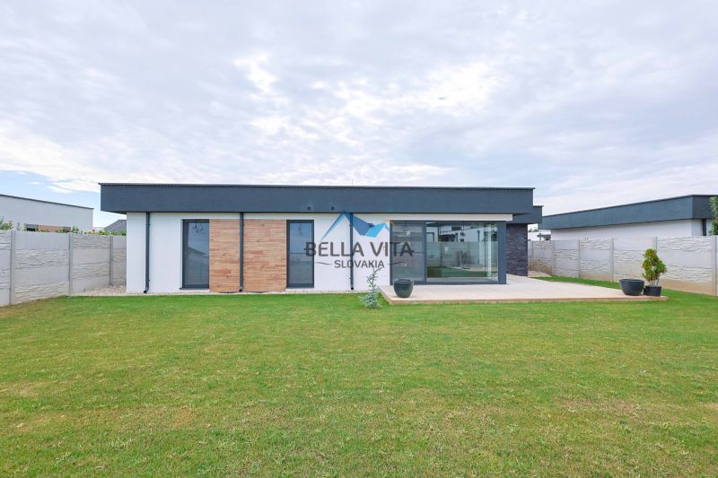 The family house on Milénium Street in Košúty has wooden cladding and a landscaped garden.