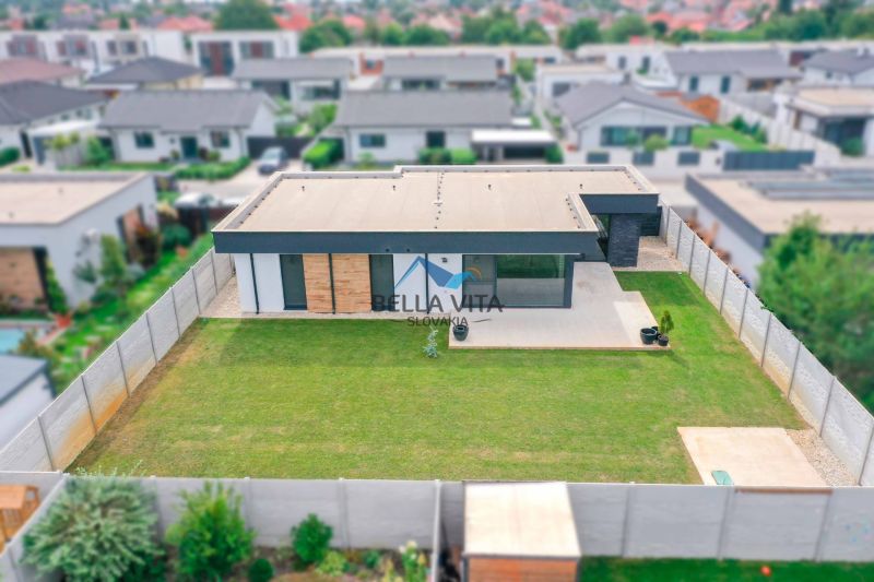 A family house on Milénium Street, Košúty, with a flat garden and minimalist design.