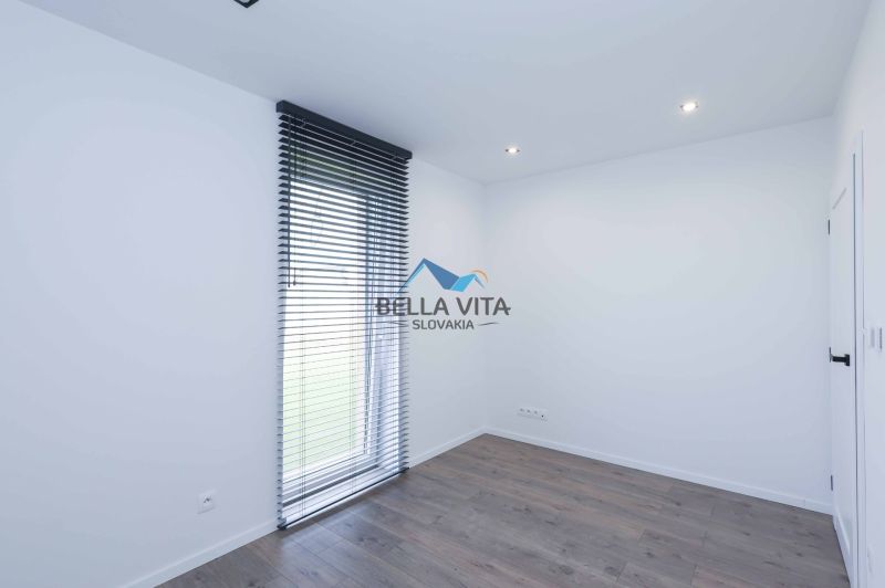 A room in a family house with a floor featuring a wooden decor and vertical blinds.