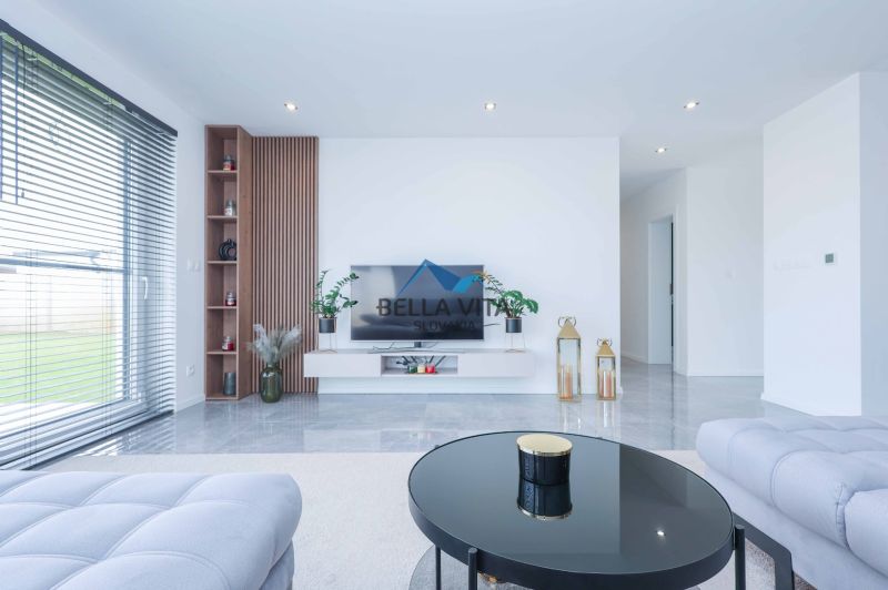 Living room in a family house with a sofa, television, window, and decorative elements.