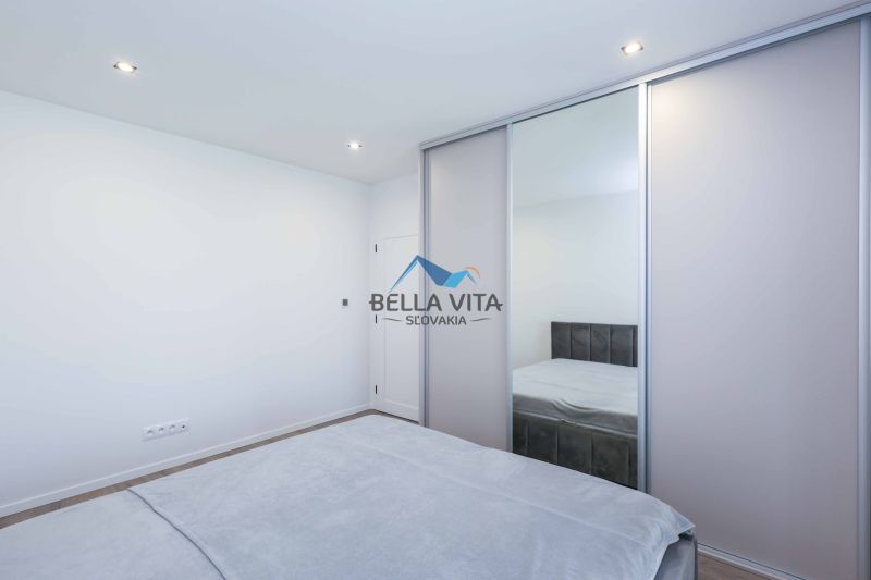 Bedroom with sliding wardrobe and bed in a family house, floor with wooden decor.