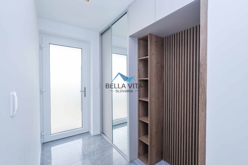 Entrance hallway in a family house with a wooden decor floor and a mirror.