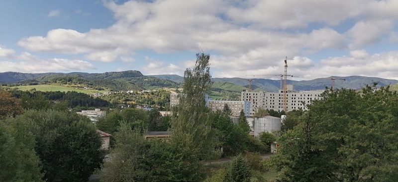 View of the Banská Bystrica skyline from Astrova with apartment buildings and landscape scenery.
