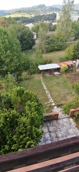 The garden of a family house on Astrová Street in Banská Bystrica with a gazebo and trees.