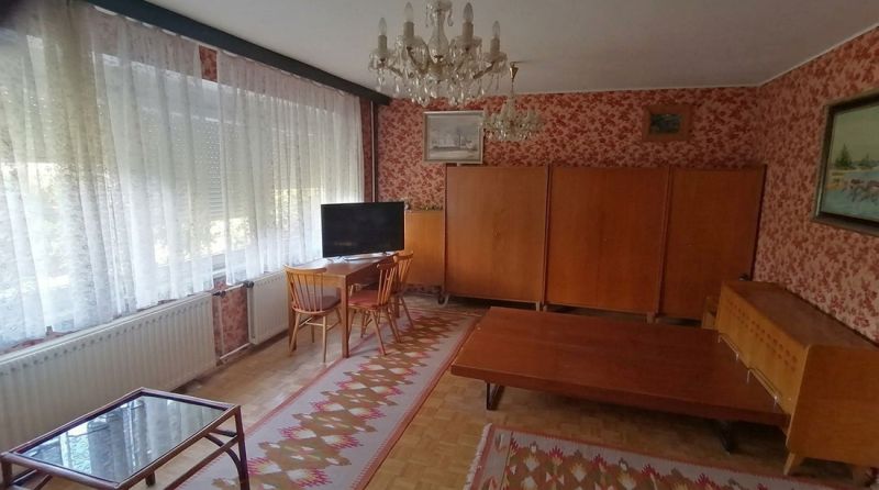 Living room in a family house with carpets and wooden furniture, floor with wood decor.