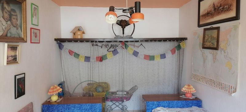 A room in a family house with decorations, a world map, and tables with lamps.