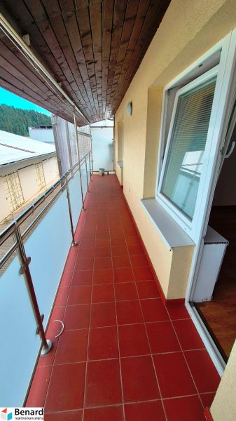 A balcony with tiles and a wooden ceiling, leading from a 3-room apartment.