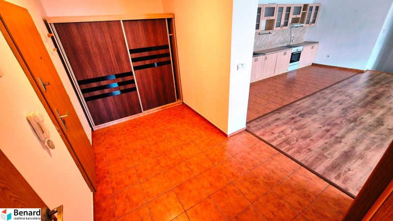 A kitchen in a 3-room apartment with a wooden decor floor and a built-in closet.