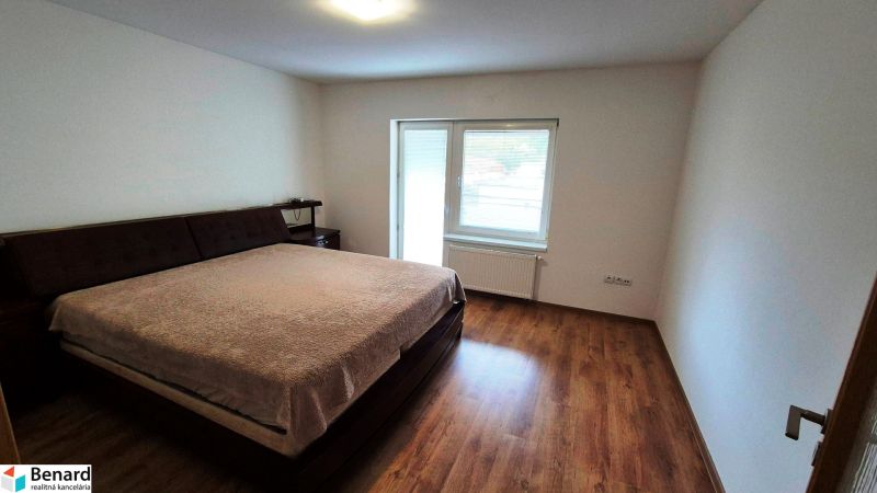 Bedroom in a 3-room apartment with a large bed and a floor with a wooden decor.
