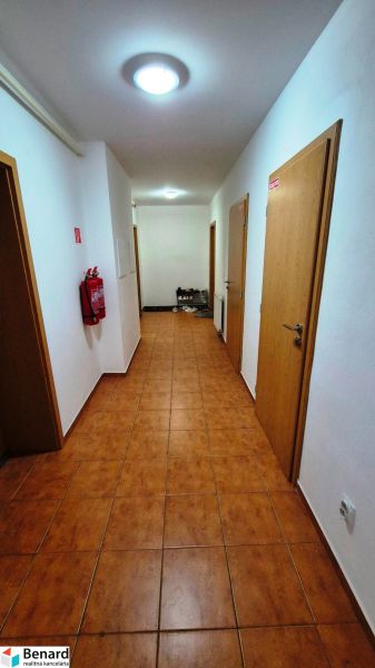 A hallway with lights and tiles, multiple doors in a 3-room apartment.