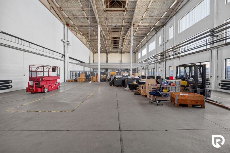 A spacious hall with a high ceiling and various equipment in warehouses and halls.