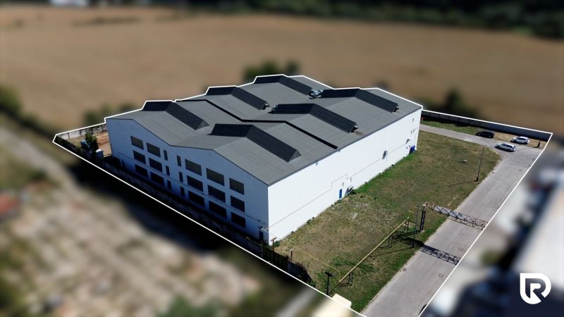 Near the warehouses and halls in Trenčín on K výstavisku Street, a modern industrial building can be seen.