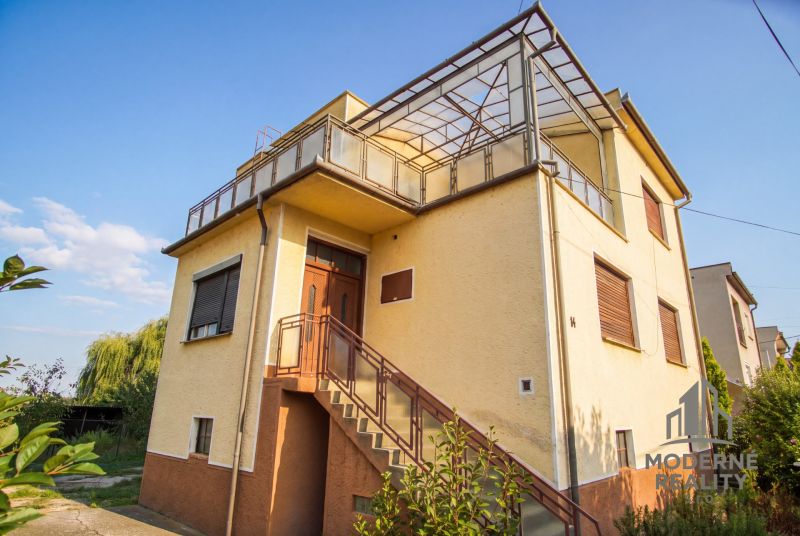 A family house in Dvory nad Žitavou with a balcony and external stairs.