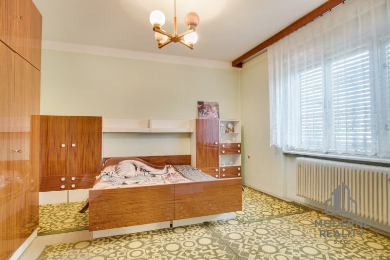 A bedroom with retro furniture in a family house, a floor with a geometric pattern.
